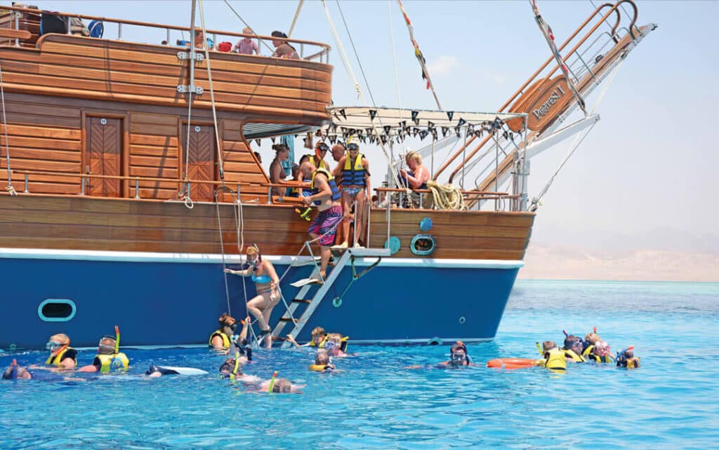 The Pirates boat in Hurghada carrying a lively group of tourists, sailing through the calm waters of the Red Sea under a clear blue sky.