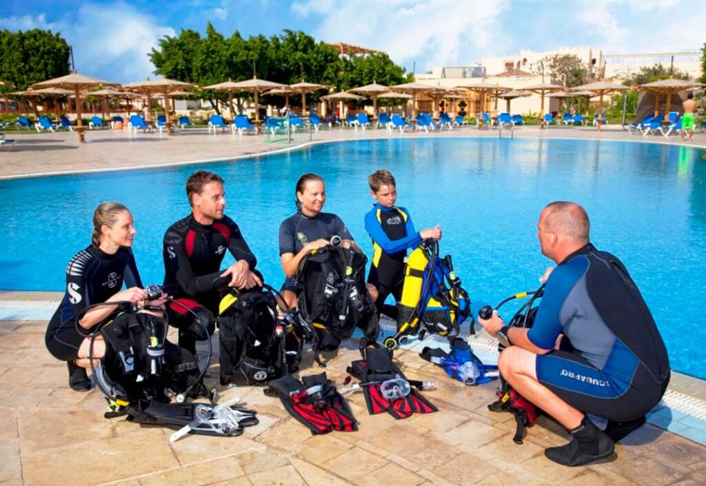 A group of new divers during training with their personal trainer in the swimming pool.