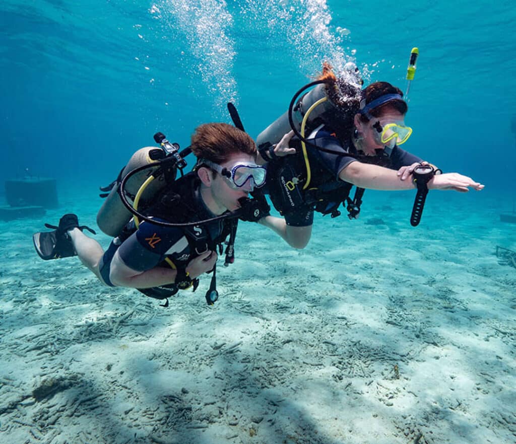 Boy and woman diving and learning directions underwater