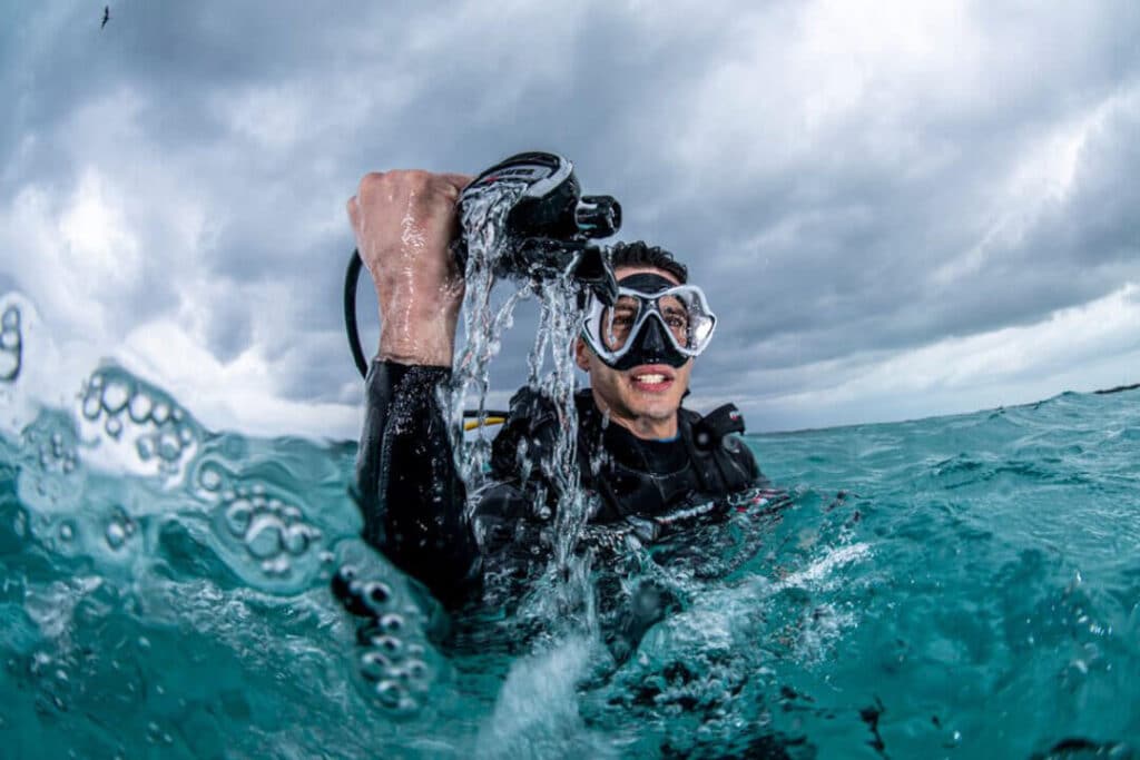 A diver in a scuba suit, complete with scuba gear, navigates the underwater environment, showcasing marine exploration.