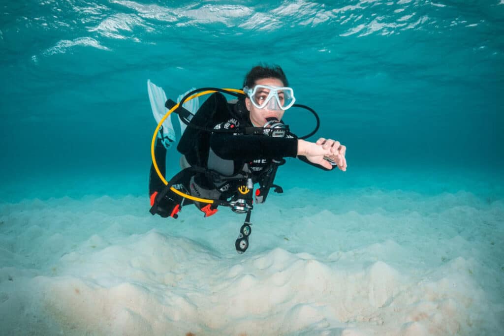 A scuba diver with a mask and goggles navigating through the ocean, showcasing the beauty of marine ecosystems.