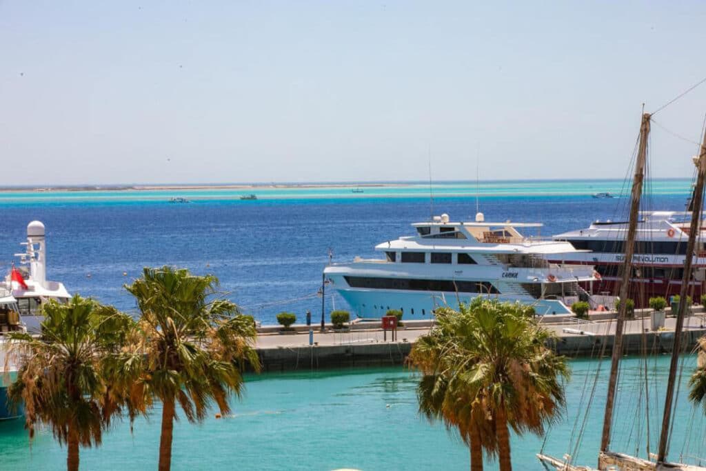 A scenic view of the harbor featuring boats gently floating on the water under a clear sky.