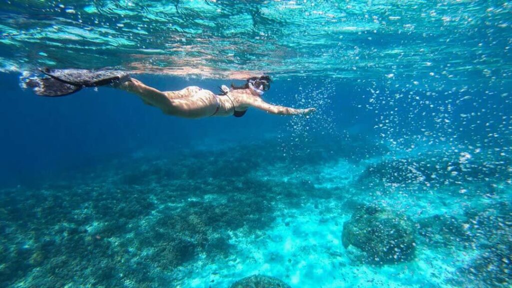 Girl snorkeling and watching marine life